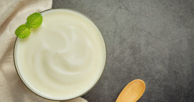 bowl of curd and wooden spoon for eating curd.